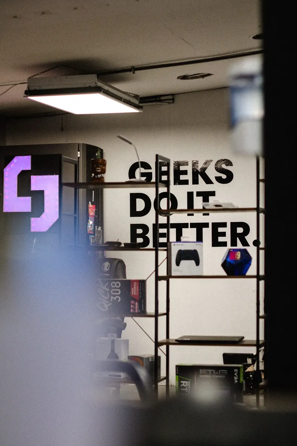 Interior del taller de Sama Geeks con el letrero Geeks do it better